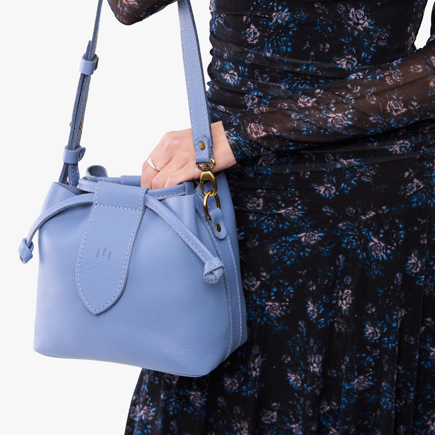 Aster*Small | Model holding symmetrical leather bag with leather drawstring closure and adjustable shoulder strap