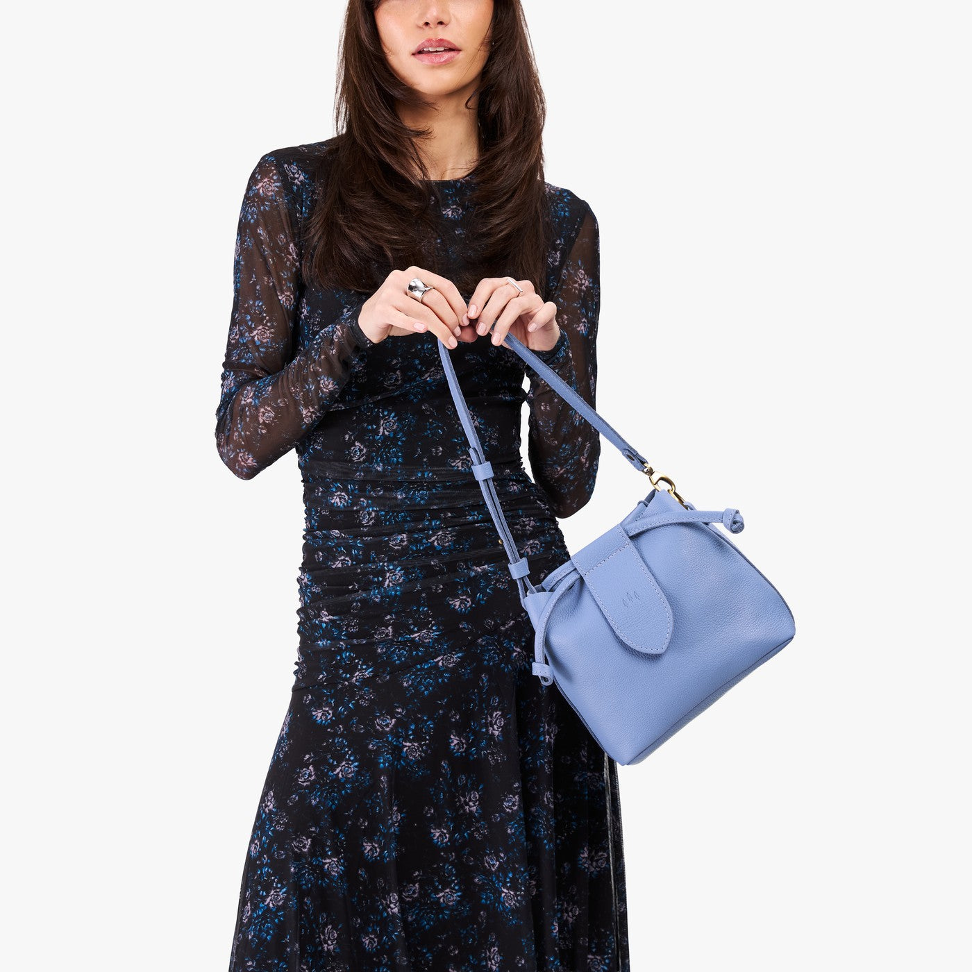 Aster*Small | Model holding symmetrical leather bag with leather drawstring closure and adjustable shoulder strap