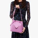 Calla Lily Small | Model holding symmetrical leather bag with leather drawstring closure and adjustable shoulder strap
