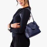 Cobalt Small | Model wearing symmetrical leather bag with leather drawstring closure and adjustable shoulder strap