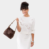 Coldbrew Small | Model holding symmetrical leather bag with leather drawstring closure and adjustable shoulder strap