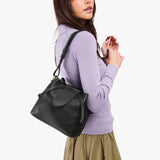 Pebbled--black Small | Model wearing symmetrical leather bag with leather drawstring closure and adjustable shoulder strap