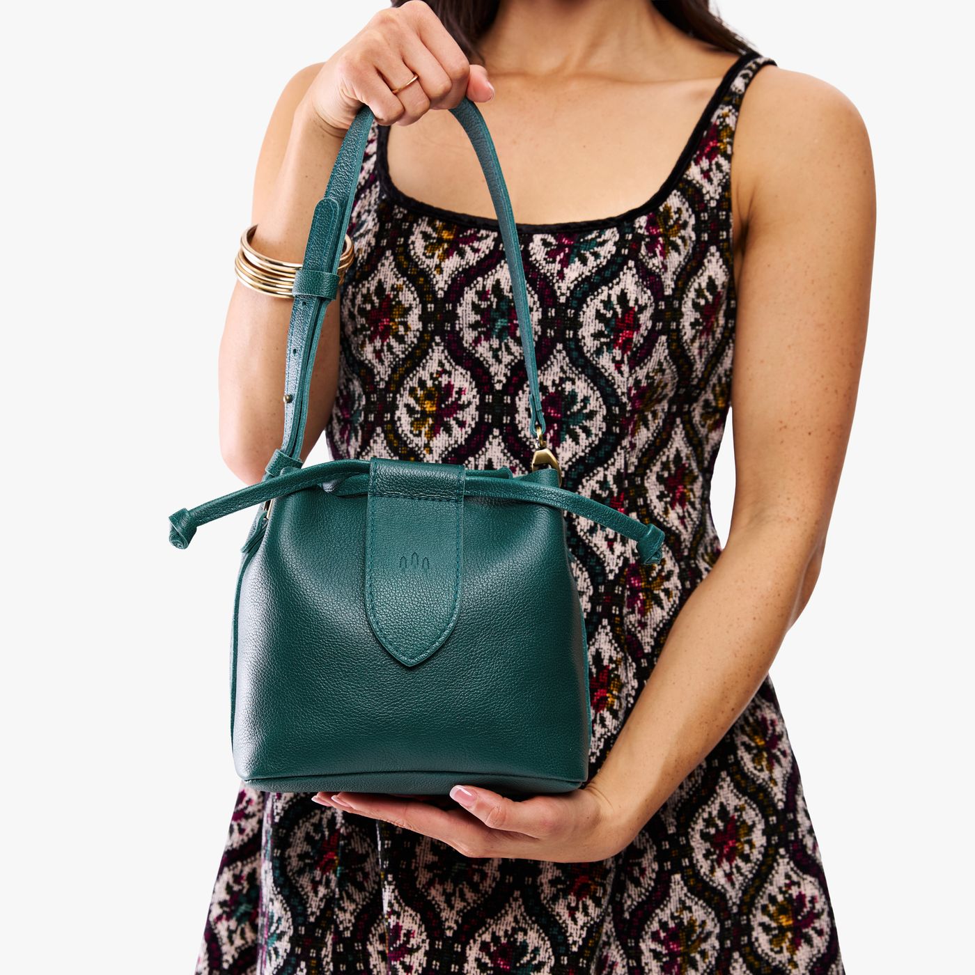 Sea Glass*Small | Model holding symmetrical leather bag with leather drawstring closure and adjustable shoulder strap