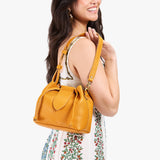 Sunshine Small | Model holding symmetrical leather bag with leather drawstring closure and adjustable shoulder strap