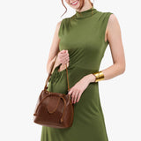 Asheville Small | Model holding symmetrical leather bag with leather drawstring closure and adjustable shoulder strap
