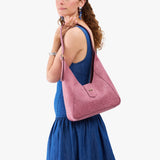 Hollyhock | Model carrying structured hobo shoulder bag with floral patterned embossed leather, adjustable strap and magnetic closure