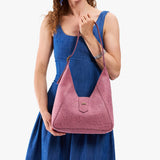 Hollyhock | Model carrying structured hobo shoulder bag with floral patterned embossed leather, adjustable strap and magnetic closure