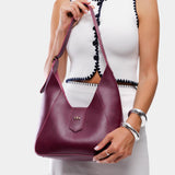Lollipop | Model holding structured hobo shoulder bag with adjustable strap and magnetic closure