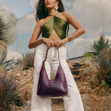 Plum | Model holding structured hobo shoulder bag with adjustable strap and magnetic closure