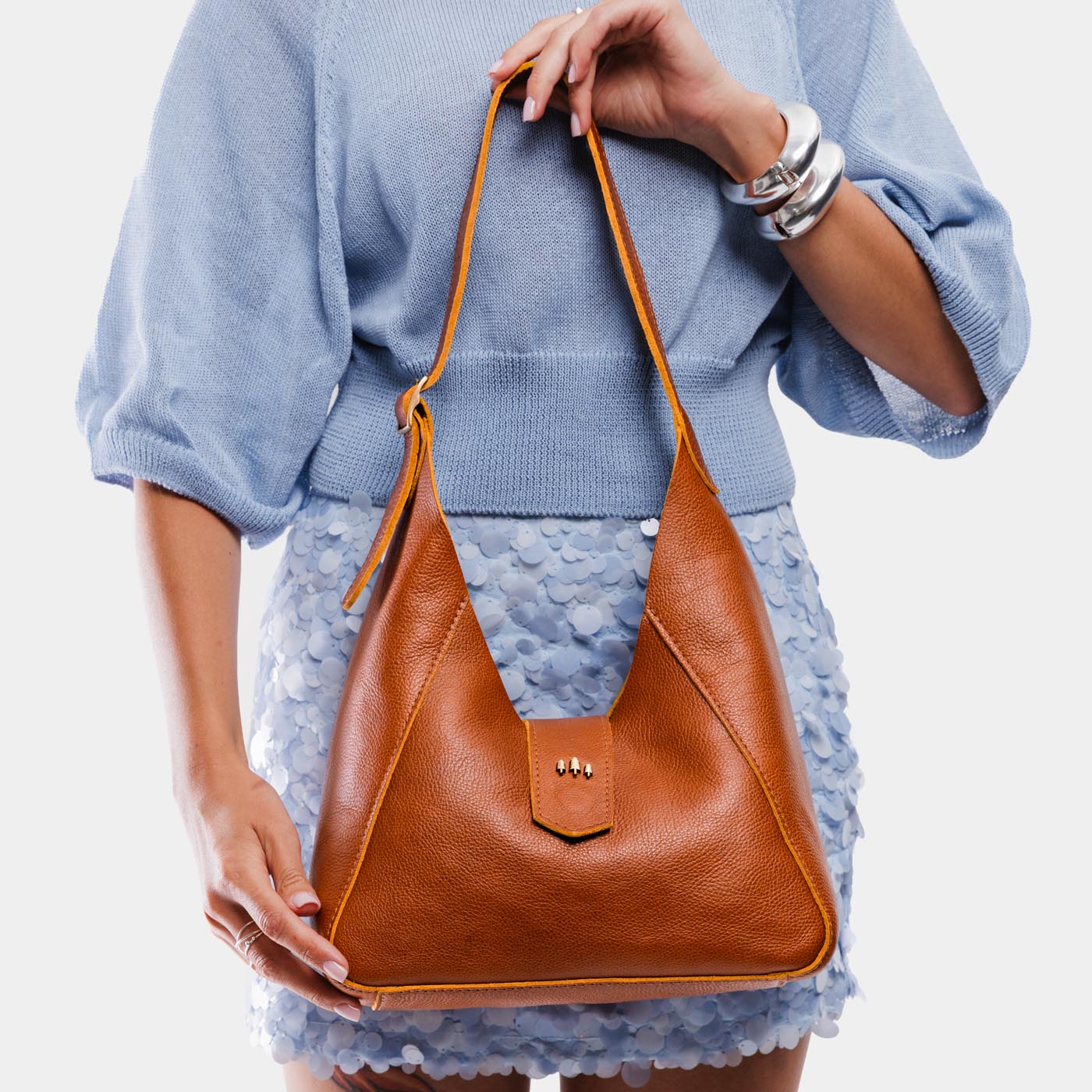 Sienna | Model holding structured hobo shoulder bag with adjustable strap and magnetic closure