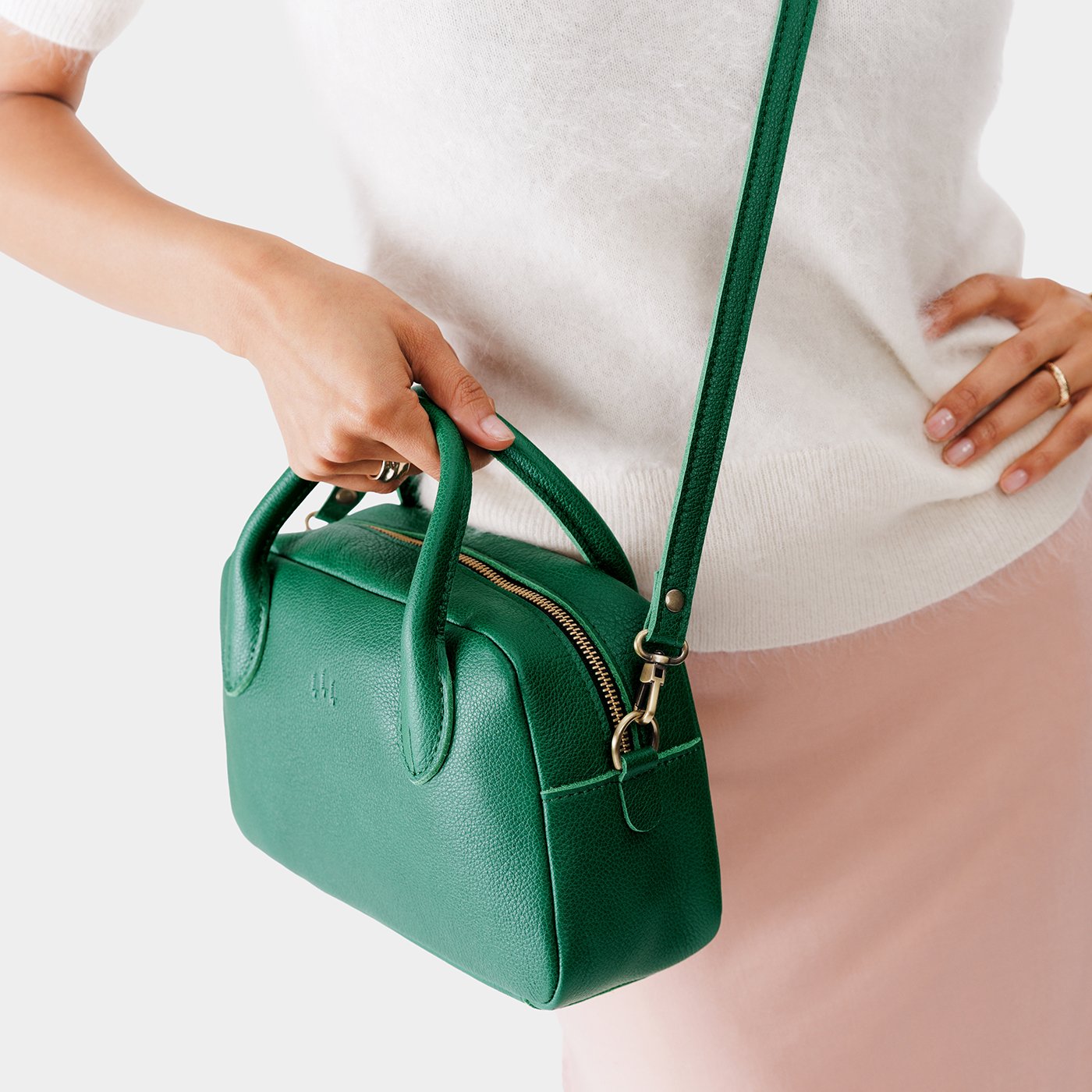 Bacalar*Large | A large bowler styled bag with a crossbody strap being worn by a model in a white knit top