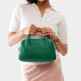 Bacalar Large | A large bowler styled bag with a crossbody strap being held by a model in a white knit top