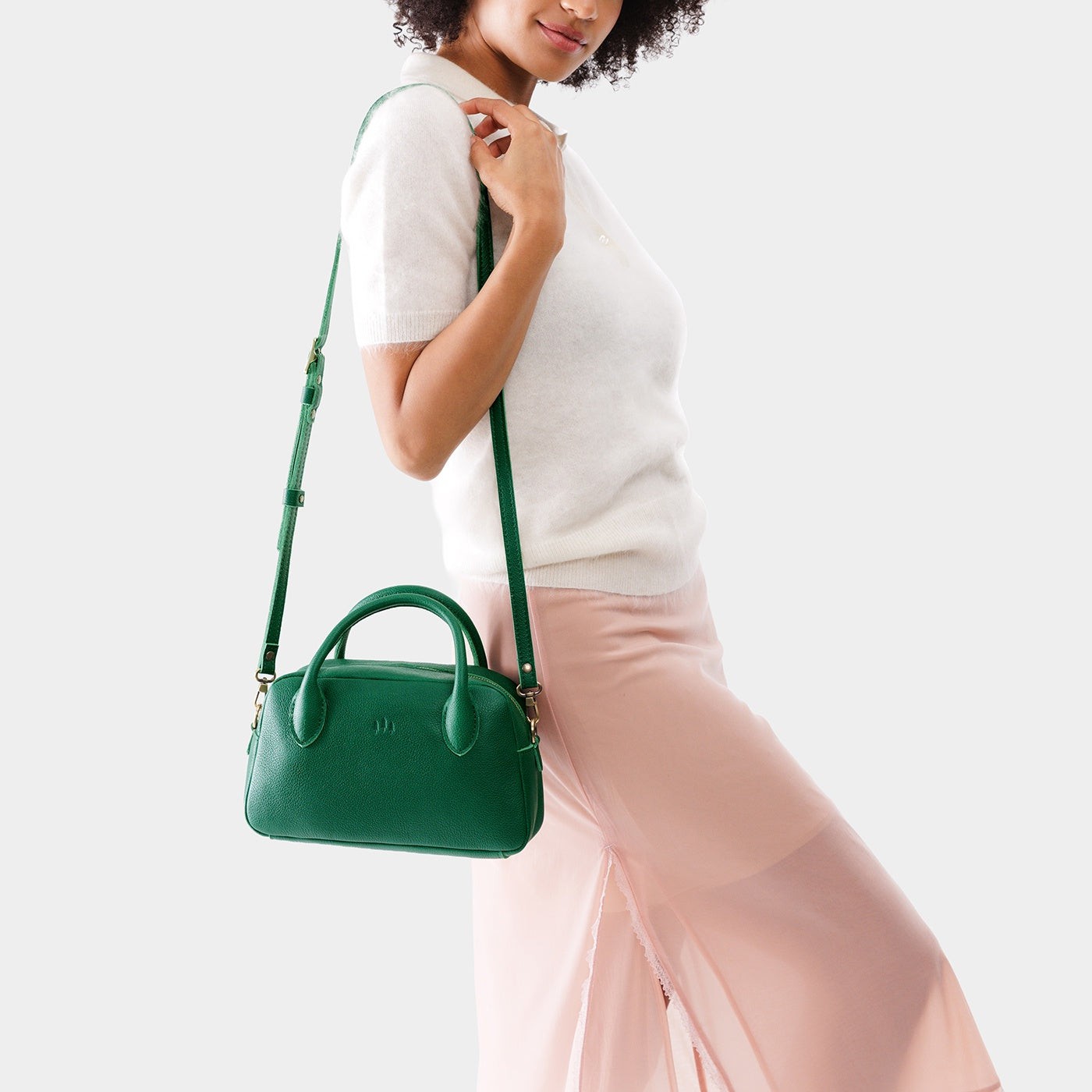 Bacalar*Large | A large bowler styled bag with a crossbody strap being worn by a model in a white knit top