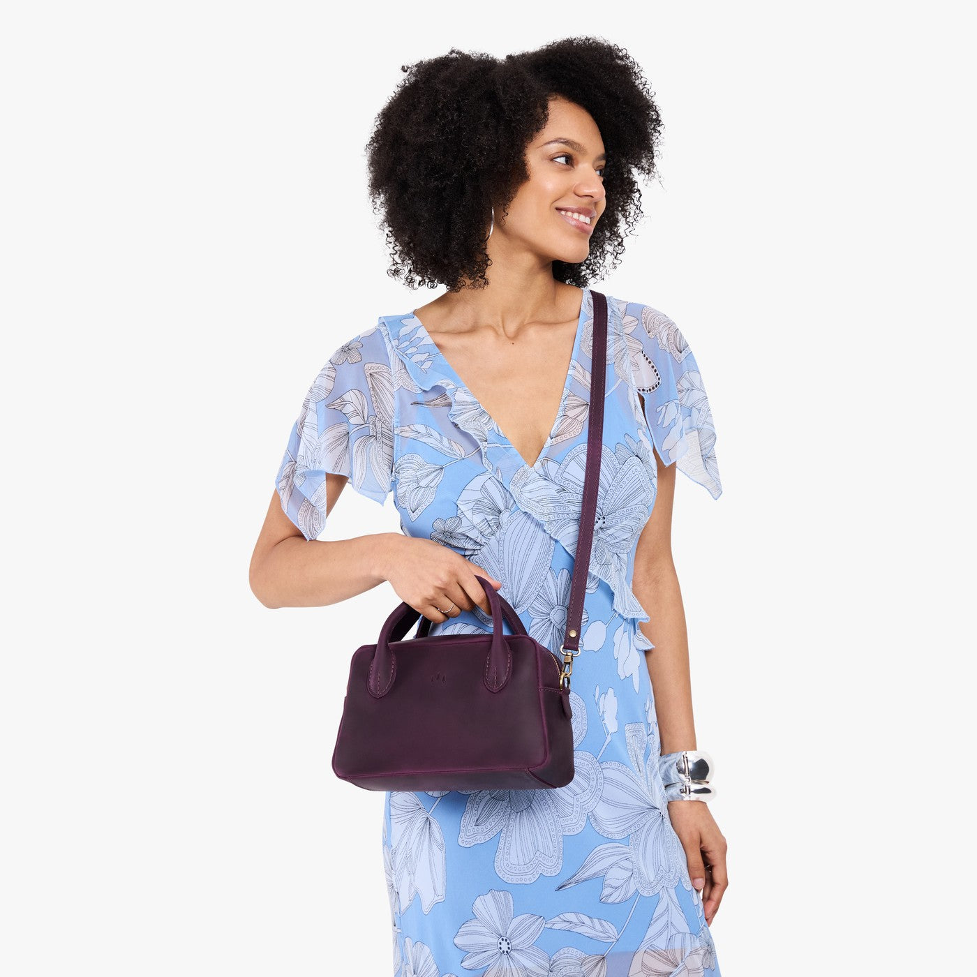 Larkspur*Large | A large bowler styled bag with a crossbody strap being worn by a model in a light blue floral dress