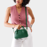 Bacalar Small | A bowler styled bag with a crossbody strap being worn by a model wearing a pink knit vest