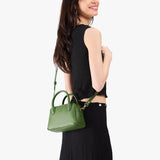 Cactus Small | A large bowler styled bag with a crossbody strap being worn by a model in a black outfit
