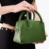 Cactus Small | A large bowler styled bag with a crossbody strap being worn by a model in a black outfit