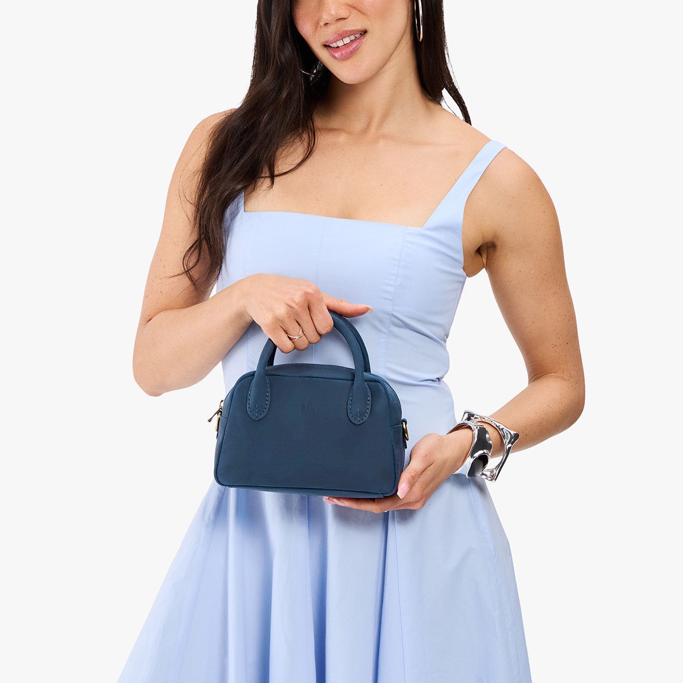Deep Water*Small | A bowler styled bag being held by a model in a light blue dress