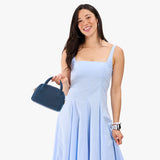Deep Water Small | A bowler styled bag being held by a model in a light blue dress
