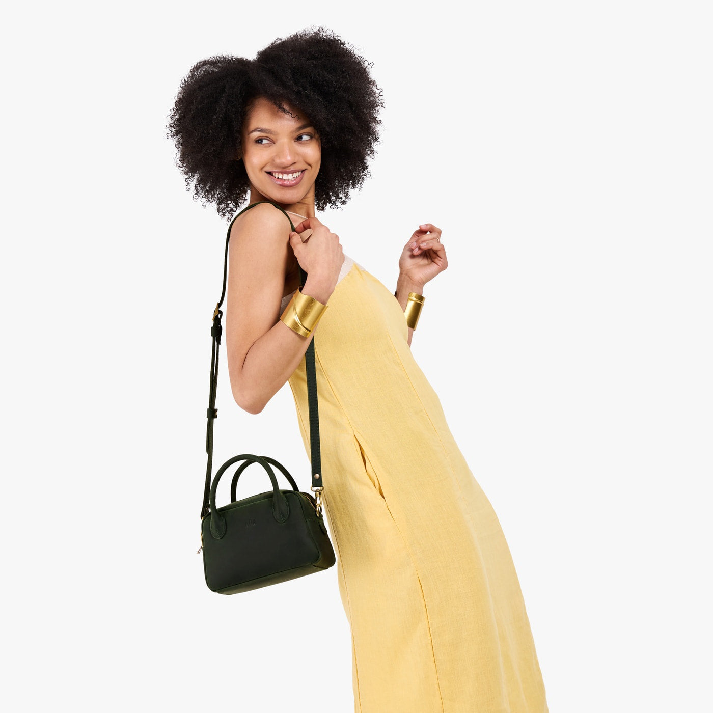 Evergreen*Small | A bowler styled bag with a crossbody strap being worn by a model in a yellow dress