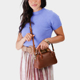Nutmeg Small | A Bowler style purse with a crossbody strap being worn by a model