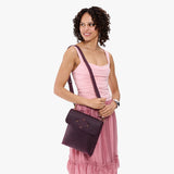 Larkspur | Model carrying slim satchel bag with crossbody strap and flap with magnet snap closure