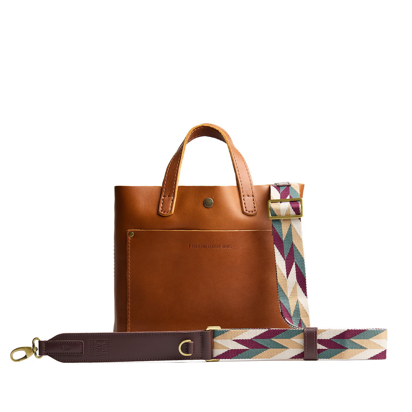 Mystic Motion | Patterned fabric and leather strap attached to leather purse on a white background