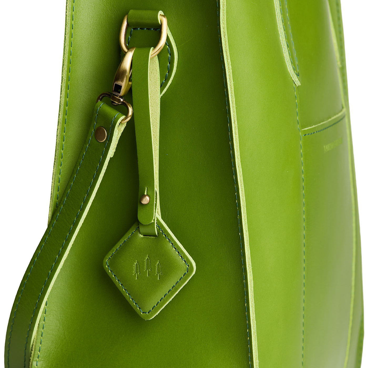 Green Apple | Rhombus-shaped leather tag with a strap and debossed PLG design hanging from a green leather bag