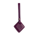 Plum | Rhombus-shaped leather tag with a strap and debossed PLG design