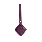 Plum | Rhombus-shaped leather tag with a strap and debossed PLG design