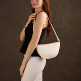 Pebbled Bone Medium | Model wearing half circle shaped sling bag