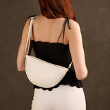 Pebbled Bone Medium | Model wearing half circle shaped sling bag