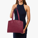 Orchid Large | Model carrying leather tote bag with handles, adjustable crossbody strap, and two back pockets