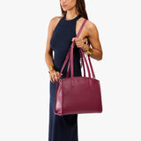 Orchid Large | Model carrying leather tote bag with handles, adjustable crossbody strap, and two back pockets