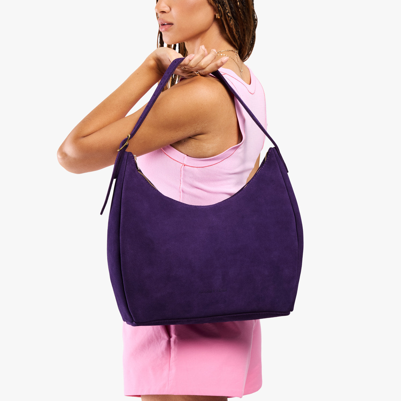 Imperial*Large | Model holding u-shaped, flat-bottomed leather shoulder bag with adjustable strap