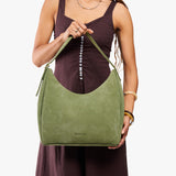 Laurel Large | Model holding u-shaped, flat-bottomed leather shoulder bag with adjustable strap