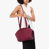 Orchid Large | Model holding a half circle crossbody bag with handles and removable crossbody strap