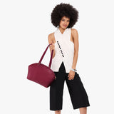 Orchid Large | Model holding a half circle crossbody bag with handles and removable crossbody strap