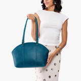 Planetary Large | Model holding a half circle crossbody bag with handles and removable crossbody strap