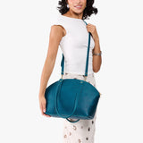 Planetary Large | Model holding a half circle crossbody bag with handles and removable crossbody strap