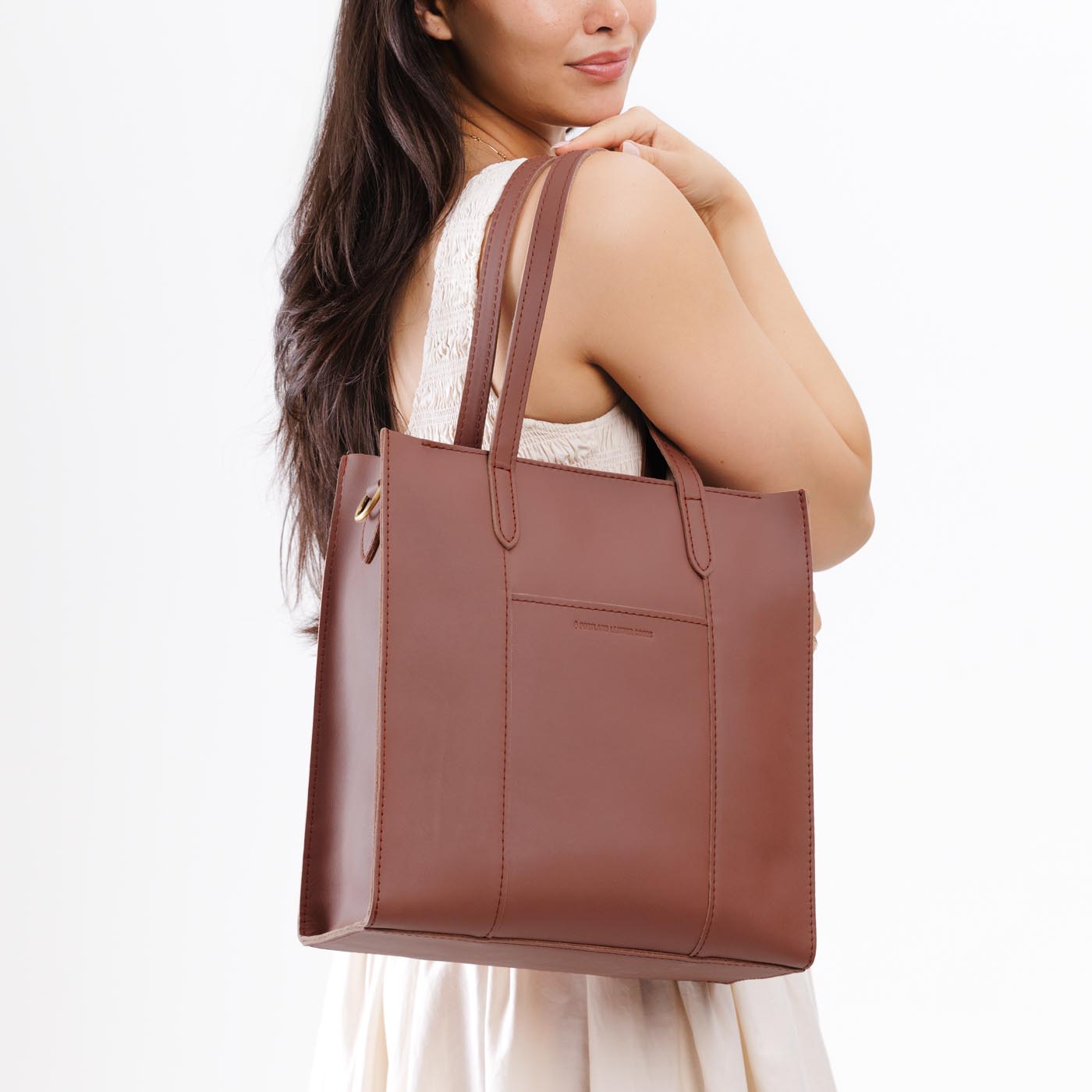 Sunkissed*North/South | Model wearing structured large tote bag with overlapping panels and crossbody strap