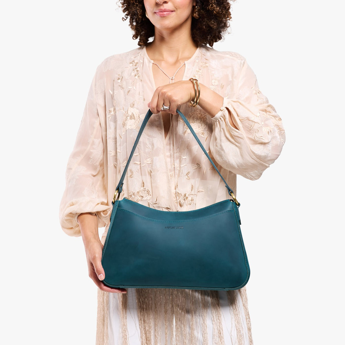 Westward Blue*Large | Model holding a bean shaped shoulder bag with a zipper closure