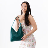 Sea Glass Large | Model wearing petite shoulder bag with adjustable strap and magnetic snap closure