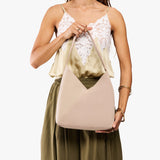 Toasted Oat Large | Model holding mid-size shoulder bag with magnetic snap closure