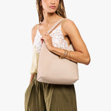 Toasted Oat Large | Model holding mid-size shoulder bag with magnetic snap closure