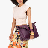 Plum Large | Model wearing a convertible tote clutch crossbody