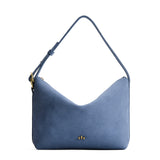 Denim Large | Slouchy Shoulder Bag that has a zipper opening and three metal tree emblems on a white background