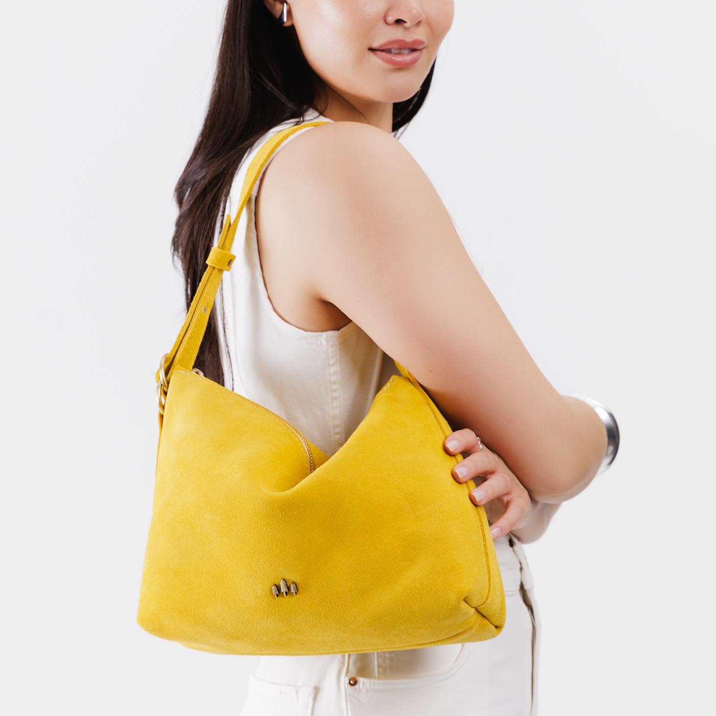 Hello Yellow*Large | Model wearing medium sized slouchy leather shoulder bag with zipper opening and three metal tree emblems