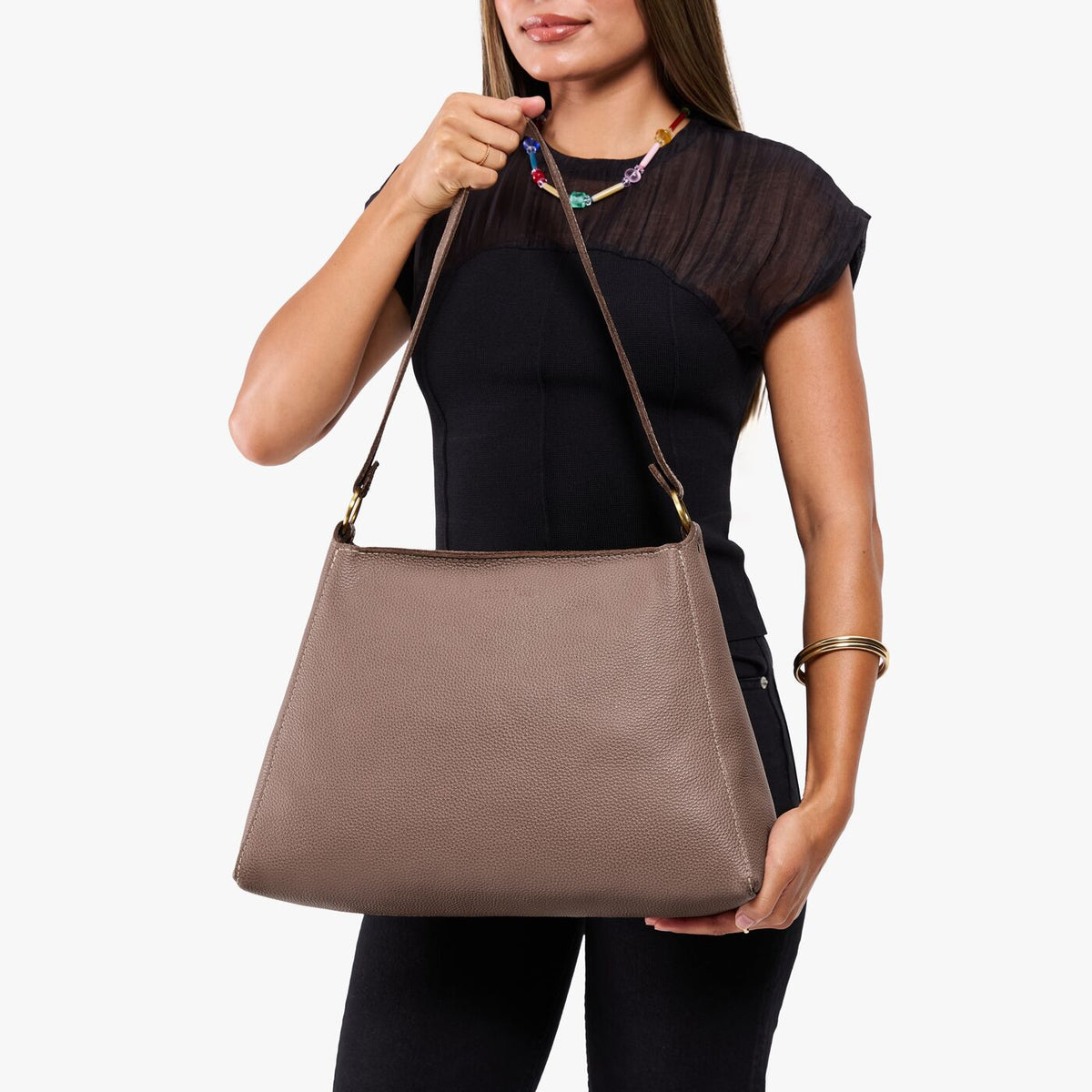 Sparrow*Large | Model holding a triangular shoulder bag with antiqued brass finished 