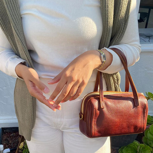 person standing and holding a Sloan Crossbody Bag in Nutmeg